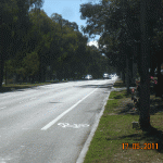 Figure 2: Right: Looking from the bus stop towards cars stopped at traffic signals at the nearest safe crossing. The memorial wreath and phone booth are at the right.